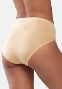 Beige korkeavyötäröiset alushousut, jotka on valmistettu pehmeästä puuvillasta, jossa on sileä pinta ja pitsireunus vyötäröllä, tarjoten täydellistä peittävyyttä takana.