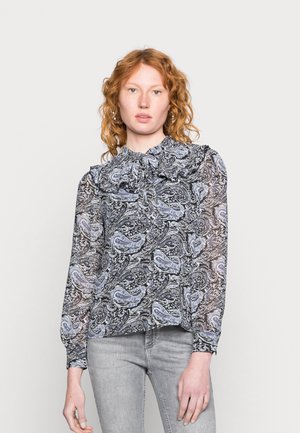 Blusa em paisley Preto e Azul com gola franzida, mangas longas transparentes e tecido texturizado; usada com jeans cinza-claro.