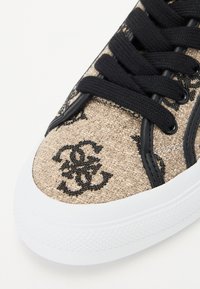 Sneaker in tela con una trama beige intrecciata, dettagli in logo nero, lacci neri e suola in gomma bianca.