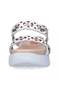 Sandalo bianco con design a taglio e dettagli metallici, dotato di cinturino alla caviglia e suola flessibile bianca. Sottopiede testurizzato per il comfort.
