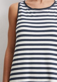 Marineblauw en wit gestreept tanktop gemaakt van zachte katoen. Heeft een ronde halslijn en brede armgaten, met stikdetails rond de randen.