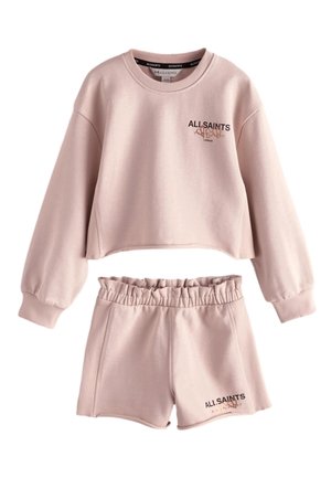 Lyserød cropped sweatshirt med lange ærmer og elastiske shorts med AllSaints-logo og lille teksttryk på begge dele.