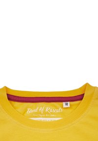 Gul T-shirt med korta ärmar och rund halsringning; har en vinröd detalj på insidan av kragen; mjukt material av ekologisk bomull.