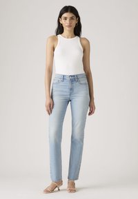 Lichtblauwe jeans met hoge taille in een rechte snit. De stof heeft een zachte, vervaagde textuur met contrasterende stiksels en een ontwerp met vijf zakken.