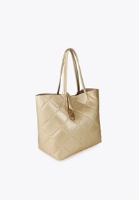 Złota torebka typu tote ze wzorem pikowanym, z dwiema rączkami i ozdobnym zapięciem, na jednolitym tle. Elegancki i stylowy design.