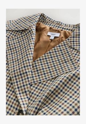 Blazer carreauté avec une doublure beige clair. Le motif se compose de carreaux bleus, bruns et crème, avec un col cranté et une fermeture à bouton.