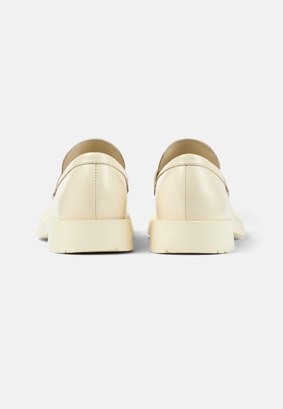 Krämfärgade läderskor med en slät yta och rundade kanter. Gummisulor och en minimalistisk design utan synlig hårdvara.