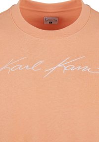 Porsjonsfarget sweatshirt med rund hals og ribbet tekstur. Har hvit brodert skrift som leser "Karl." Laget av bomull.