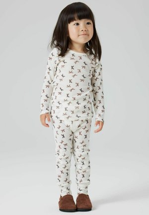 Set di pigiama bianco a maniche lunghe con motivo a fiocchi marroni ripetuto. Realizzato in morbido cotone, con pantaloni aderenti. Scarpe marroni slip-on.