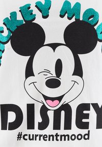Weißes T-Shirt mit einem schwarzen und pinken Mickey-Maus-Design, verziert mit glitzerndem türkisfarbenem Text, der "Mickey Mood" und "Disney" darüber und darunter liest.