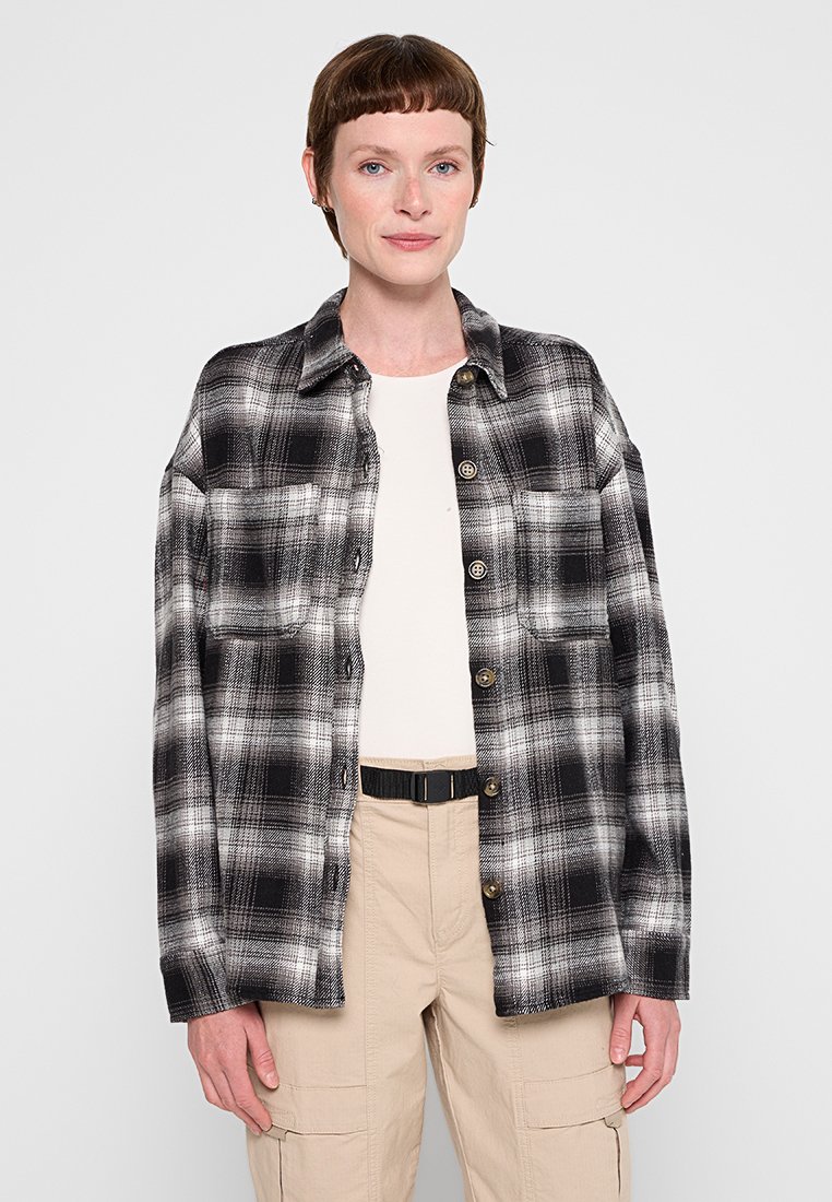 Schwarz-weiß kariertes Flanellhemd mit lockerer Passform, ausgestattet mit einem Kragen, vorderem Knopfverschluss und zwei Brusttaschen. Weiche Textur.