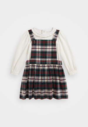 Kárované šaty s bielou dlhou rukávovou košeľou pod nimi. Šaty sú v zelených, červených a krémových farbách, majú volánový golier a zapínanie na gombíky.