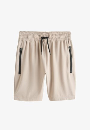 Bež šorc s elastičnim strukom, crnim vezicama i dva okomita džepa sa zipom na prednjim stranama na bijeloj pozadini.