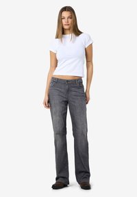 Sive rasview jeans s klasičnim dizajnom s pet džepova, u paru s uklapanjem bijelom majicom s kratkim rukavima. Glatka tekstura denima.