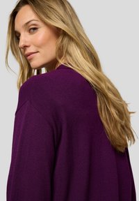 Langärmeliger lila Pullover mit strukturiertem Strickmuster. Verfügt über eine lockere Passform und leichte Faltenbildung an den Schultern. Weiches, lässiges Design.