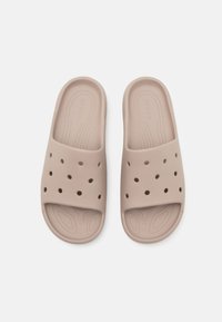 Infradito in gomma color beige chiaro con una fascia larga, caratterizzate da numerosi fori di ventilazione, una soletta testurizzata e un design liscio e flessibile.