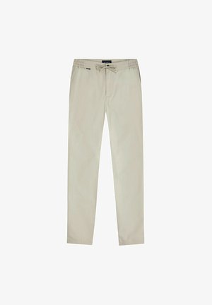 Pantalon décontracté beige avec taille élastique et cordon de serrage, coupe droite, doté de poches latérales et d'une petite étiquette de marque près de la taille.
