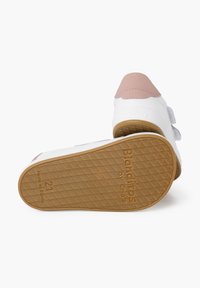 Sneaker bianca con un accento rosa sul tallone, suola in gomma testurizzata e cinturini in velcro. Presenta il marchio sul lato e sulla suola.
