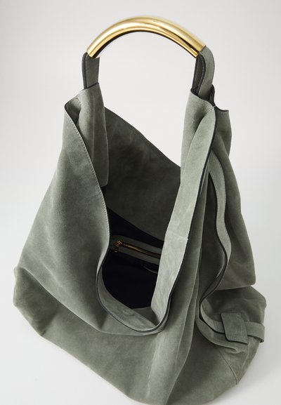 Grön mockaväskan med öppen topp, ett handtag i guldmetall och en mapp med dragkedja inuti. Har rena linjer och en mjuk textur.