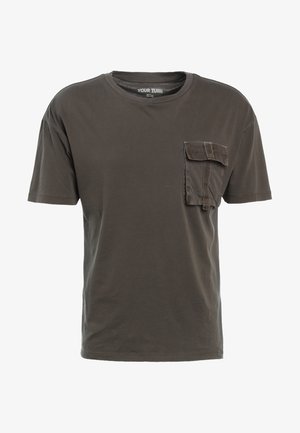 T-shirt à manches courtes gris foncé en coton, avec une poche à patch sur la poitrine gauche et un col rond. Design simple et sans embellissement.