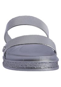Las sandalias plateadas presentan dos correas texturizadas y una suela brillante; la planta del pie lisa contrasta con los materiales elevados y reflectantes para mayor estabilidad.