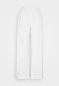 Pantalons blancs à jambes larges, confectionnés dans un tissu léger et texturé, avec une taille élastique. Présentent une coupe ample avec des jambes droites et sans poches.