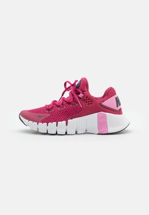 Růžové sportovní boty s síťovaným svrškem, kontrastními tmavšími růžovými akcenty a bílou, strukturovanou podrážkou s výraznými drážkami a brandingem.