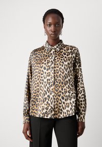Leopardmærket bluse med krave, lange ærmer og knaplukning foran. Lavet af blødt, glat stof med skinnende knapper.