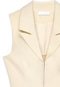 Cream-colored sleeveless blazer with a sharp, folded collar, front zipper closure, and smooth textured fabric.