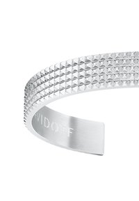Silver cuff bracelet with a textured, pyramid-stud design. Features a polished finish and engraved branding on the inner band.