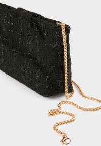 Borsa a tracolla nera con texture, realizzata in tessuto intrecciato con finitura lucida. Presenta una tracolla in catena dorata e una chiusura a scatto per una chiusura sicura.