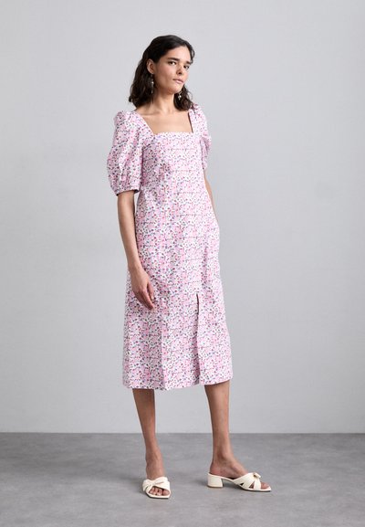 Roza midi obleka s cvetličnim vzorcem in nabranimi rokavi, kvadratičnim izrezom, stranskim razporkom in ohlapnim krojem, v kombinaciji s kremnimi sandali na blok peto.