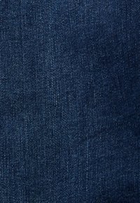 Tissu en denim bleu foncé présentant un motif classique de sergé avec des variations subtiles de texture et des fils plus clairs contrastants.