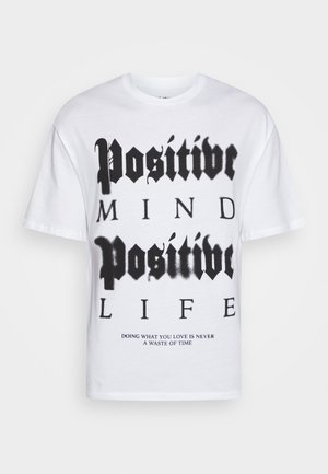 Hvid t-shirt lavet af bomuld med sort tekst: "Positivt sind, positivt liv." Nederste tekst lyder: "At gøre det, du elsker, er aldrig spild af tid."