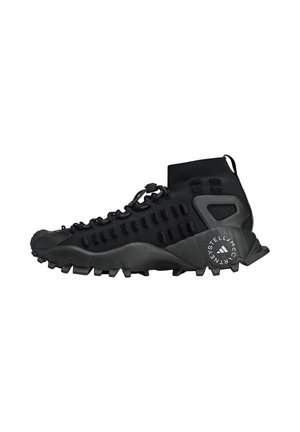 Chaussure de plein air noire avec un design à col haut, une tige texturée et une semelle robuste dotée de crampons prononcés pour une adhérence améliorée.
