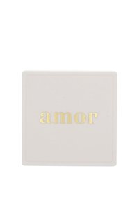 Quadratischer, blassrosa Kasten mit strukturierter Oberfläche; "amor" in goldenen Buchstaben in der Mitte geprägt. Einfaches, elegantes Design mit klaren Kanten.