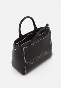 Svart läderhandväska med gyllene nitar, med en blixtlåsfack och två rundade handtag. Framsidan visar "VALENTINO" i nitar.