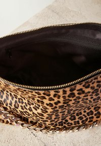 Leopardprint handtas met een gouden kettinghengsel, een ritssluiting aan de bovenkant en een soepel zwart interieur. Voorzien van gouden hardware accenten.
