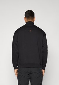Black sweatshirt with a high collar, featuring an orange star detail on the back, and ribbed cuffs. Smooth texture and relaxed fit.