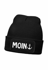 Black knitted beanie with a folded cuff featuring a rectangular patch that reads "MOIN" in bold white letters, accented by an anchor graphic.
