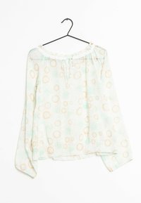 Lightweight, green blouse with long sleeves, an off-shoulder neckline, and repeating sunburst patterns in beige. Finished with a tie at the neck.