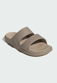 Lysebrune sandaler med to brede stropper, blødt gummimateriale, flad sål og struktureret indersål for komfort.