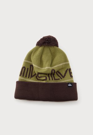 Bonnet tricoté vert et marron avec un pompon sur le dessus, bord replié marron et motif partiel de texte autour de la bande.