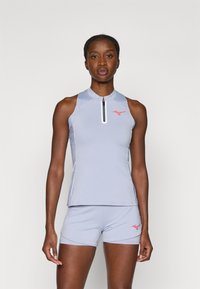 Jasnoniebieski sportowy top bez rękawów z wysokim kołnierzem, przednim zamkiem błyskawicznym i czerwonym logo, zestawiony z dopasowanymi szortami, o gładkiej fakturze i dopasowanym kroju.