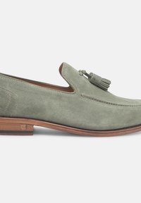 Groene suède loafers met een franjesaccent, gestructureerde vorm, contrasterende bruine leren zool en zichtbare stiksels.