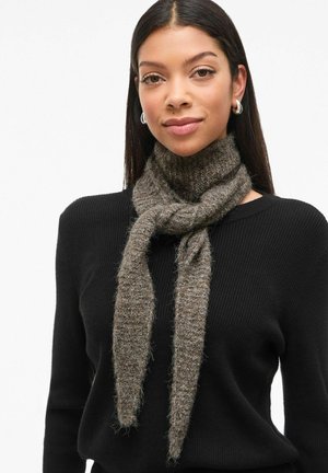 Brown textured scarf made of soft material, tied loosely around the neck. Worn with a black sweater, featuring a ribbed pattern.