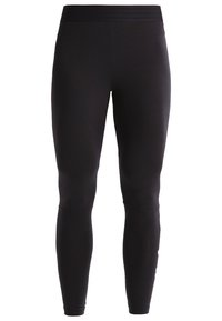 Mallas negras hechas de una tela elástica con una textura suave. Presentan una cinturilla ancha y elástica y un corte ajustado que llega hasta los tobillos.