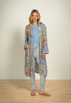 Lightweight, floral-patterned kimono in blue, worn over a striped top and patterned pants. Features pockets and flowing sleeves.