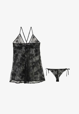Set di lingerie in pizzo nero trasparente con motivi floreali, composto da un babydoll con spalline sottili e slip coordinati con fiocchi laterali.