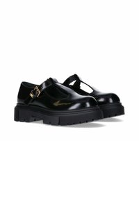 Scarpe Mary Jane in vernice nera con suola spessa nera, caratterizzate da una fascia a T e un dettaglio in fibbia dorata. Design con punta arrotondata.
